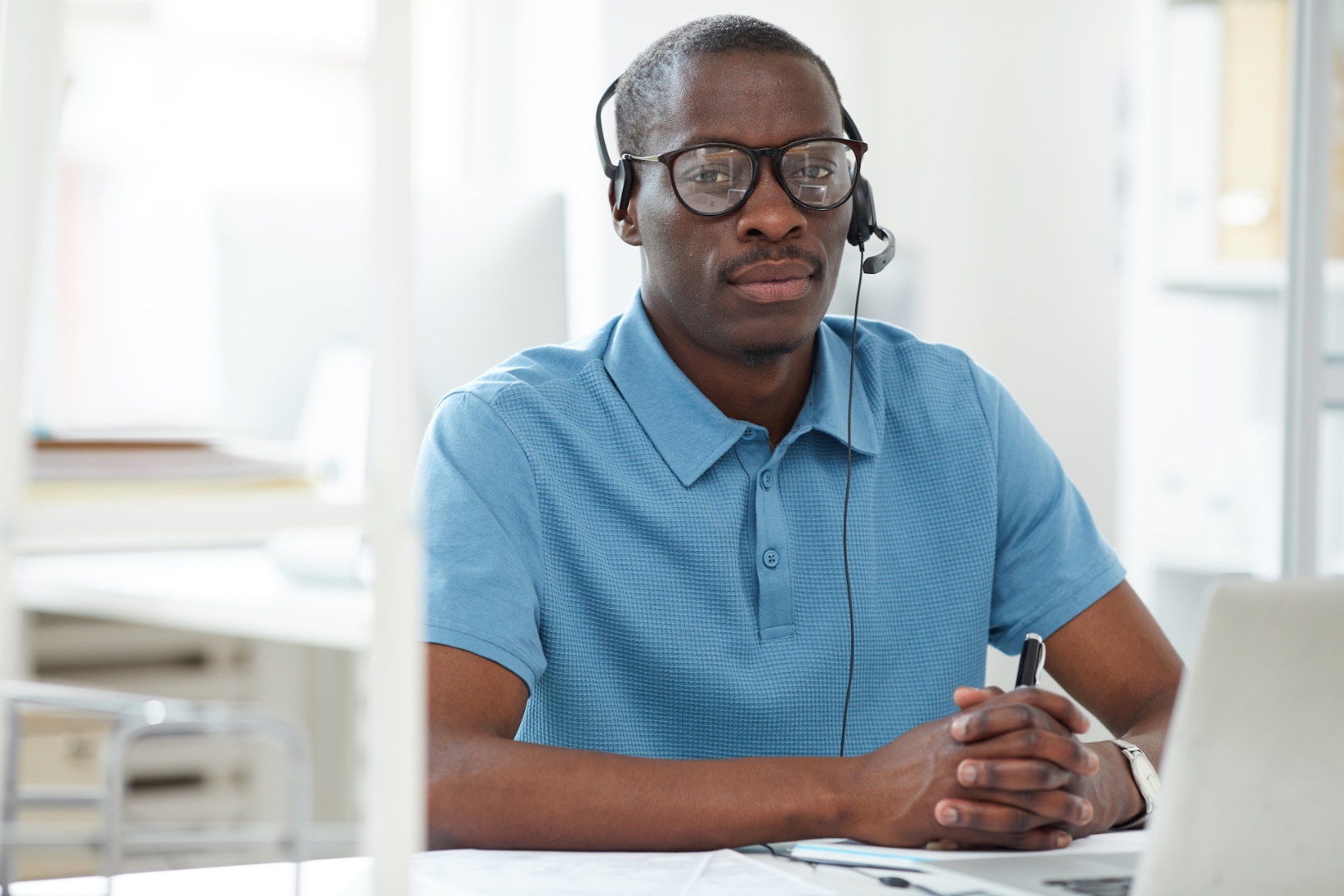 Helpdesk technician supporting clinic staff by headset and laptop